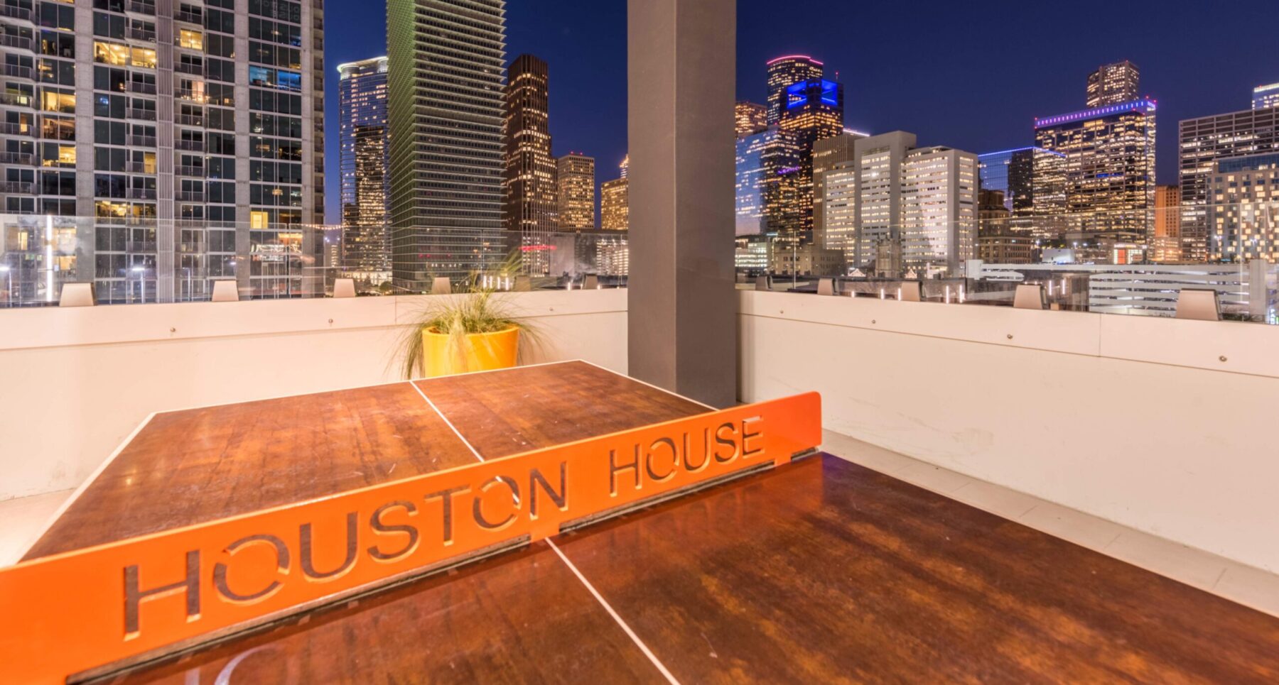 a ping pong table on a rooftop deck with view of the city skyline
